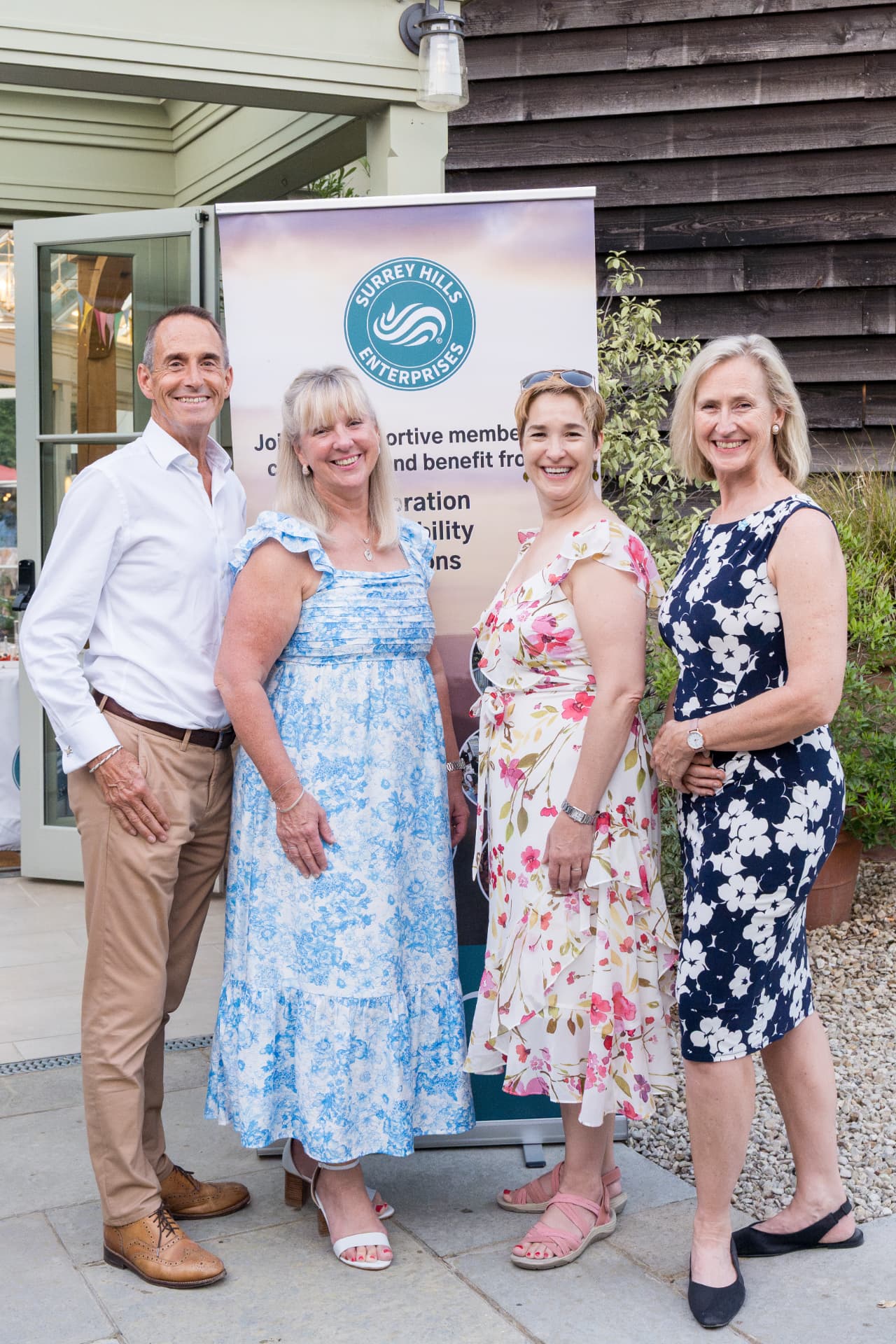 Representatives from the University of Surrey and Surrey Hills Enterprises standing together in front of a partnership banner