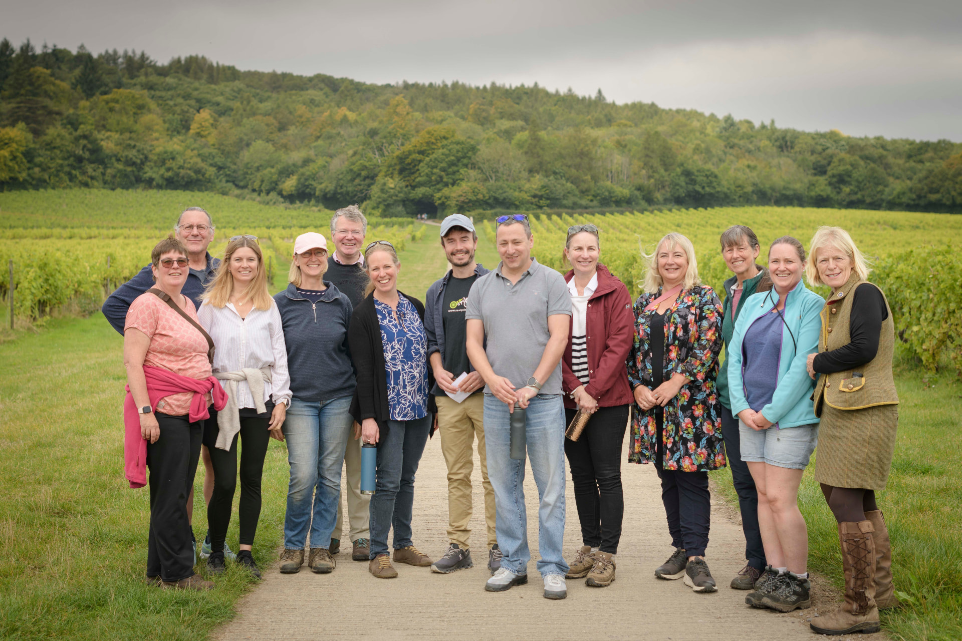 Members gathered together beside vines during a Surrey Hills vineyard visit