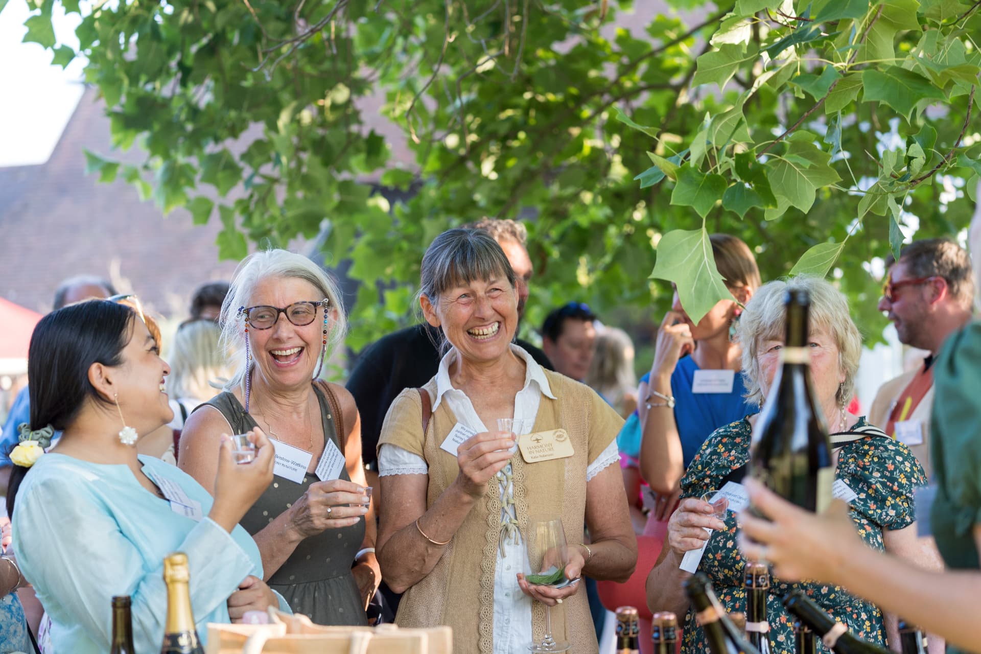 Two members laughing together with glasses during a Silent Pool gin tasting reception