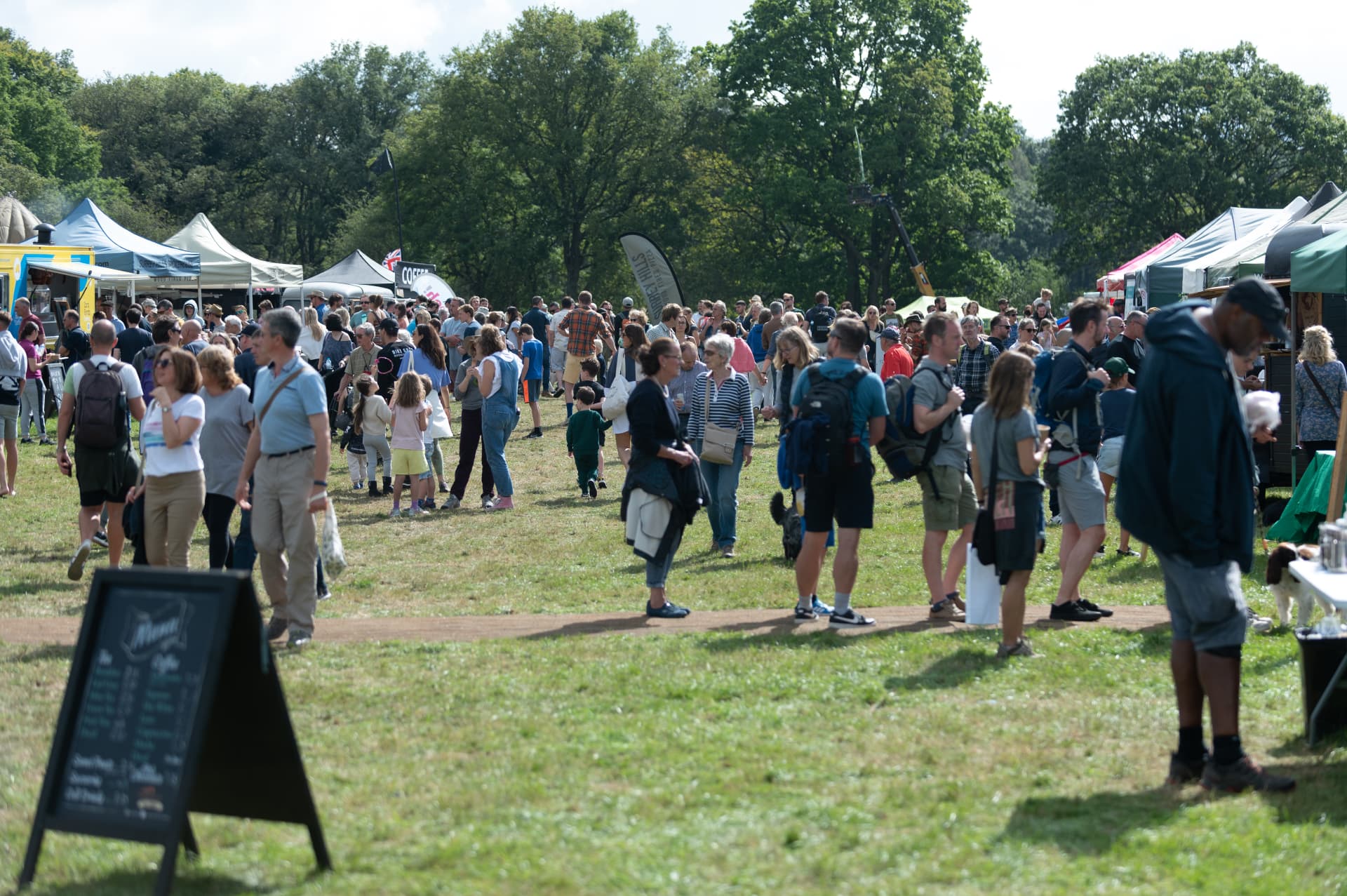 Visitors browsing food and drink stalls at a busy Surrey Hills outdoor event
