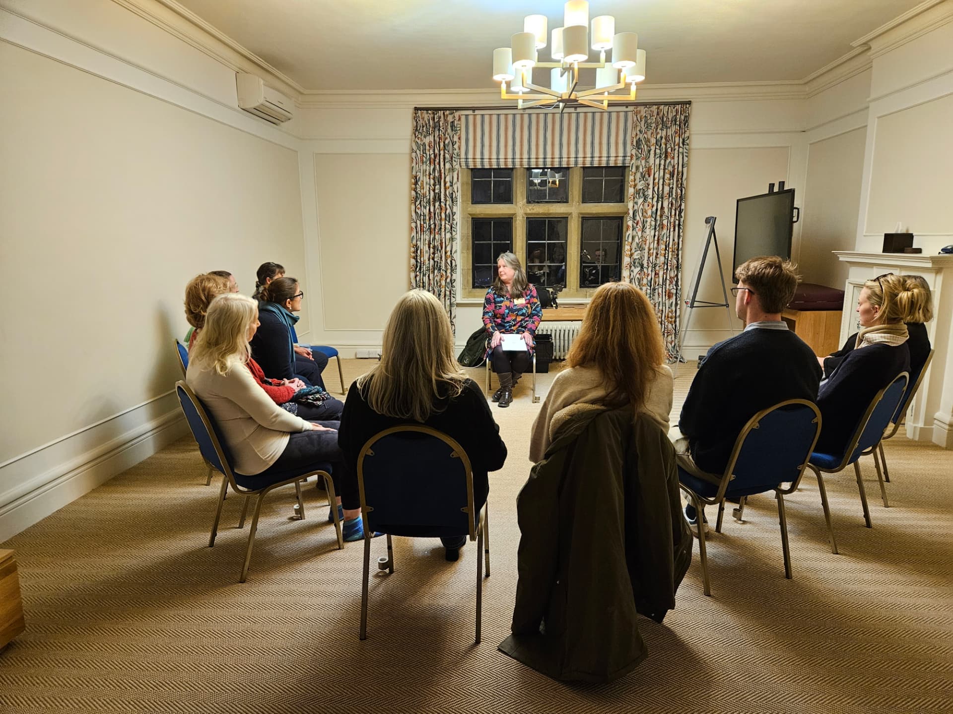Members seated in a circle listening to a speaker at a wellbeing networking evening