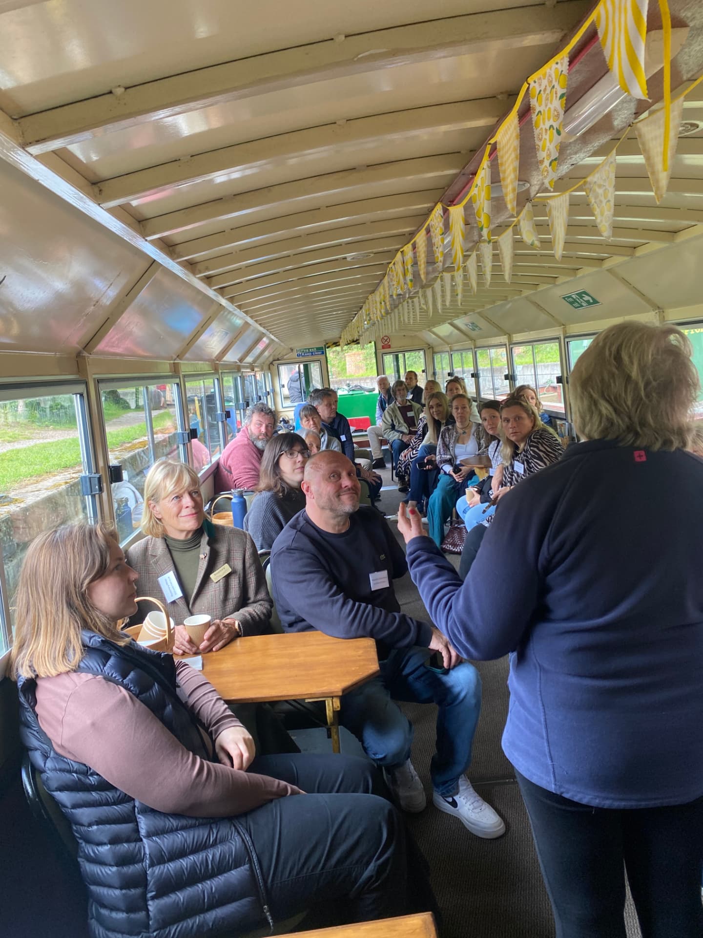 Members listening to a host aboard a canal boat during a networking trip