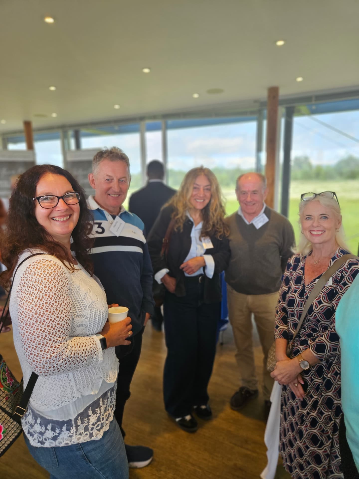 Members smiling together over coffee at a Surrey Hills Enterprises networking morning