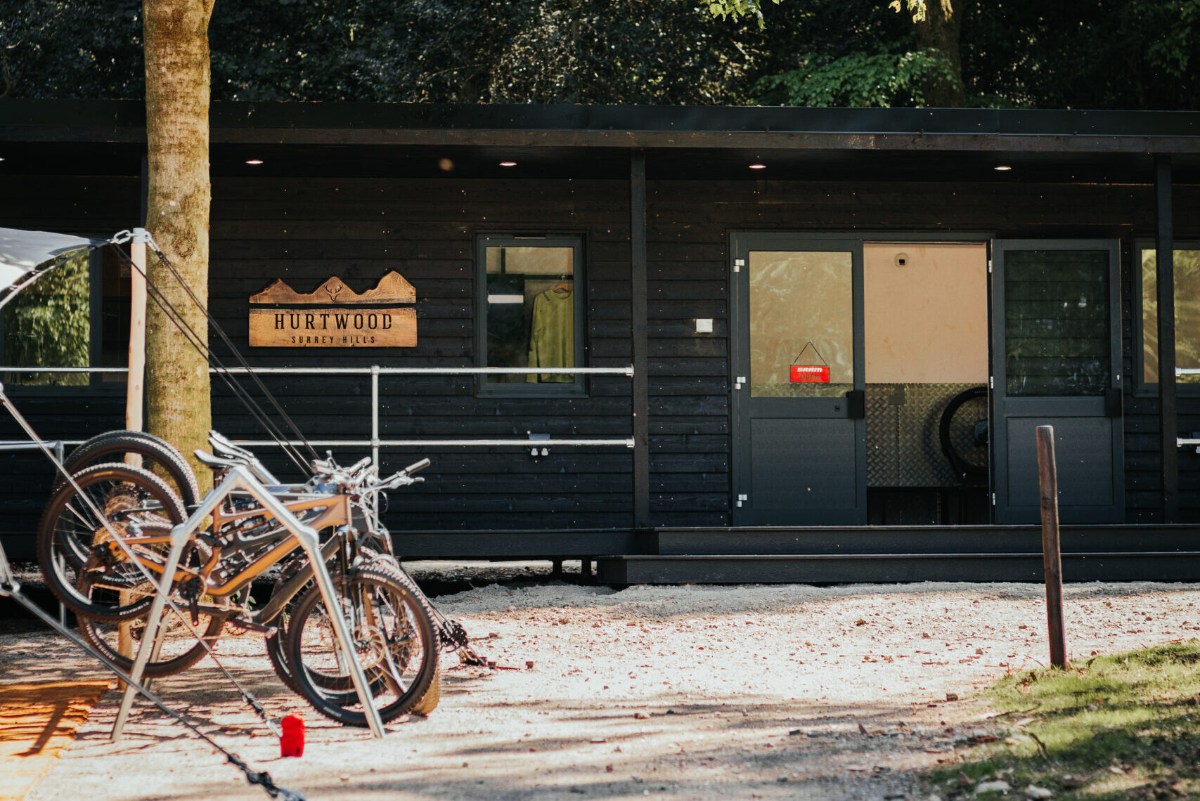 Cyclists riding through the woodland at Hurtwood Hideout