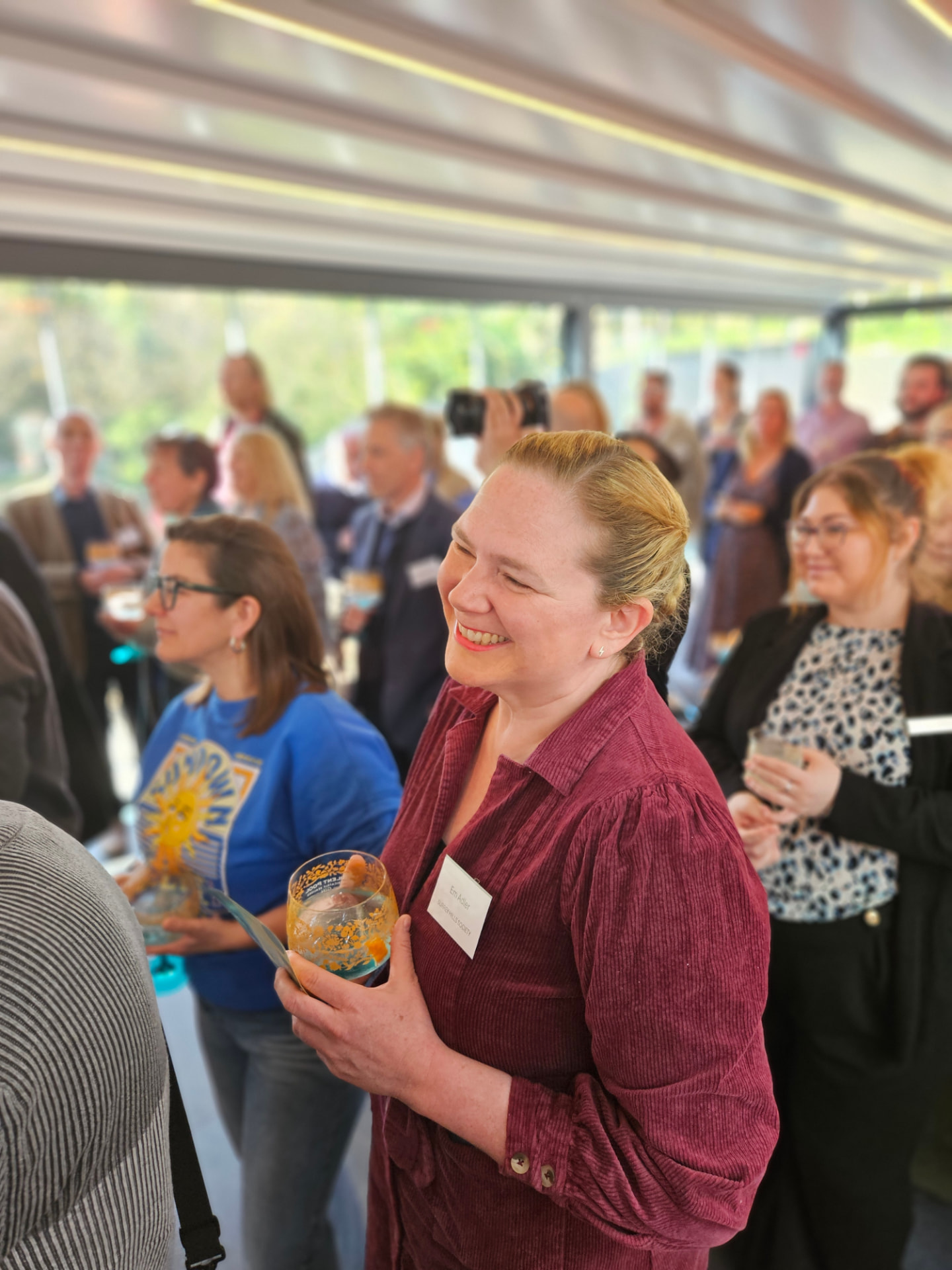 A member laughing with others during a drinks reception