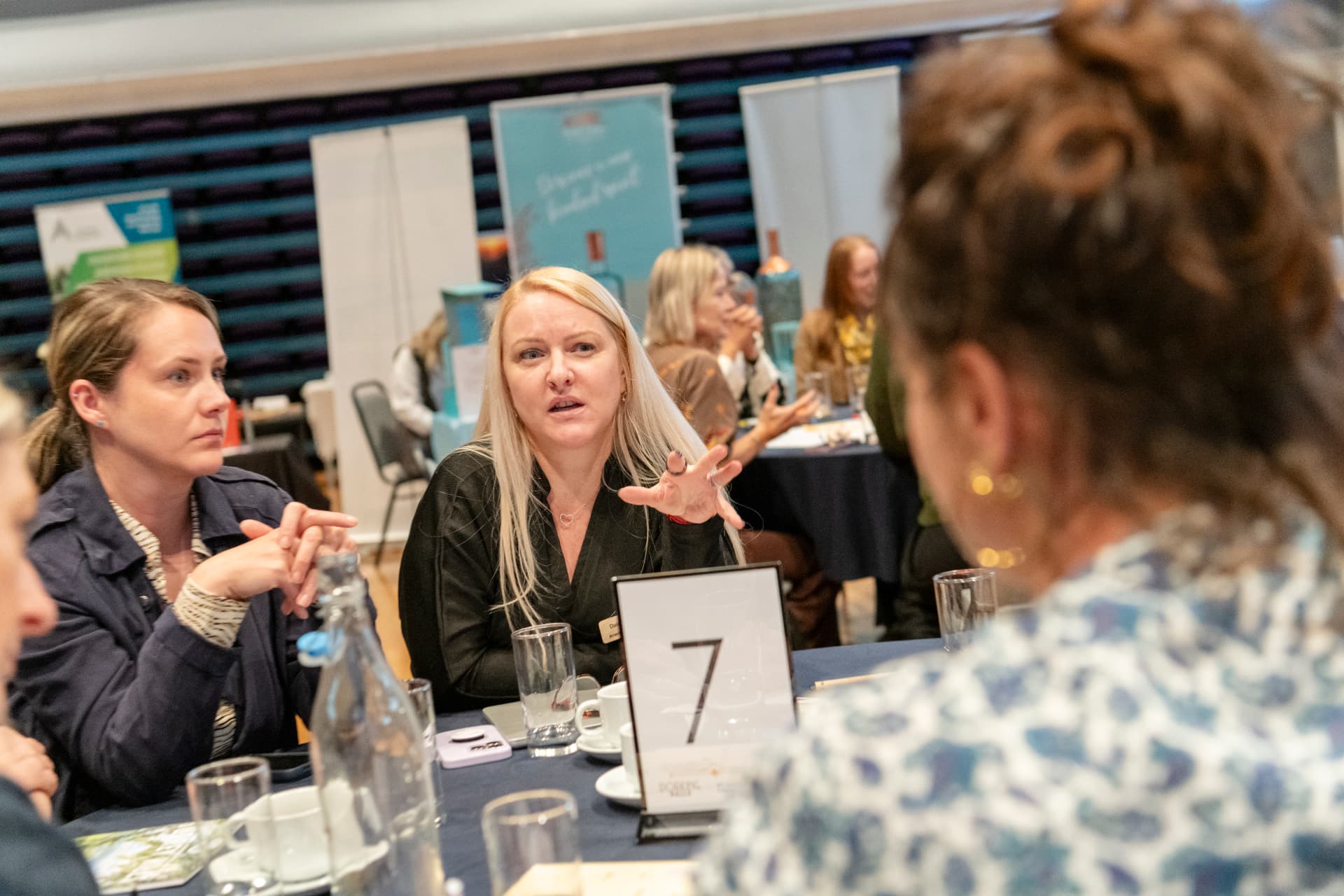 Members deep in conversation around a table at a networking session