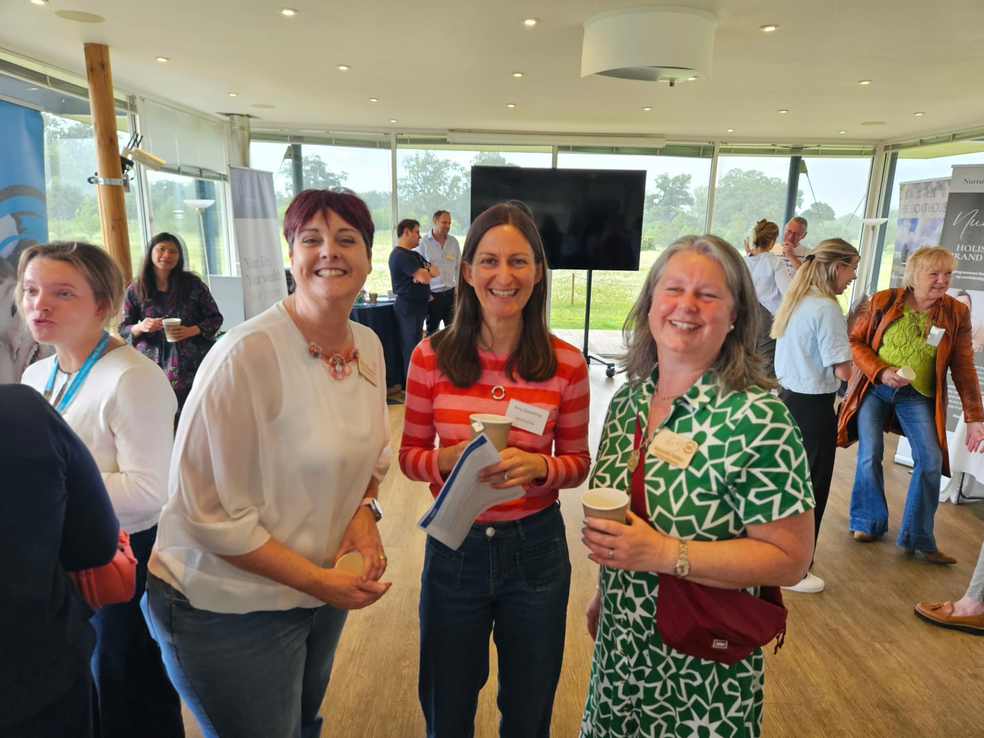 Three members laughing together during a busy networking morning at the Boathouse