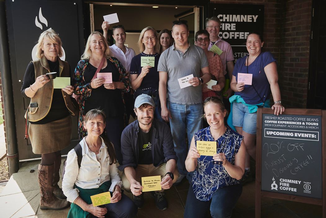 Members holding their goals on cards after a netwalk at Chimney Fire Coffee