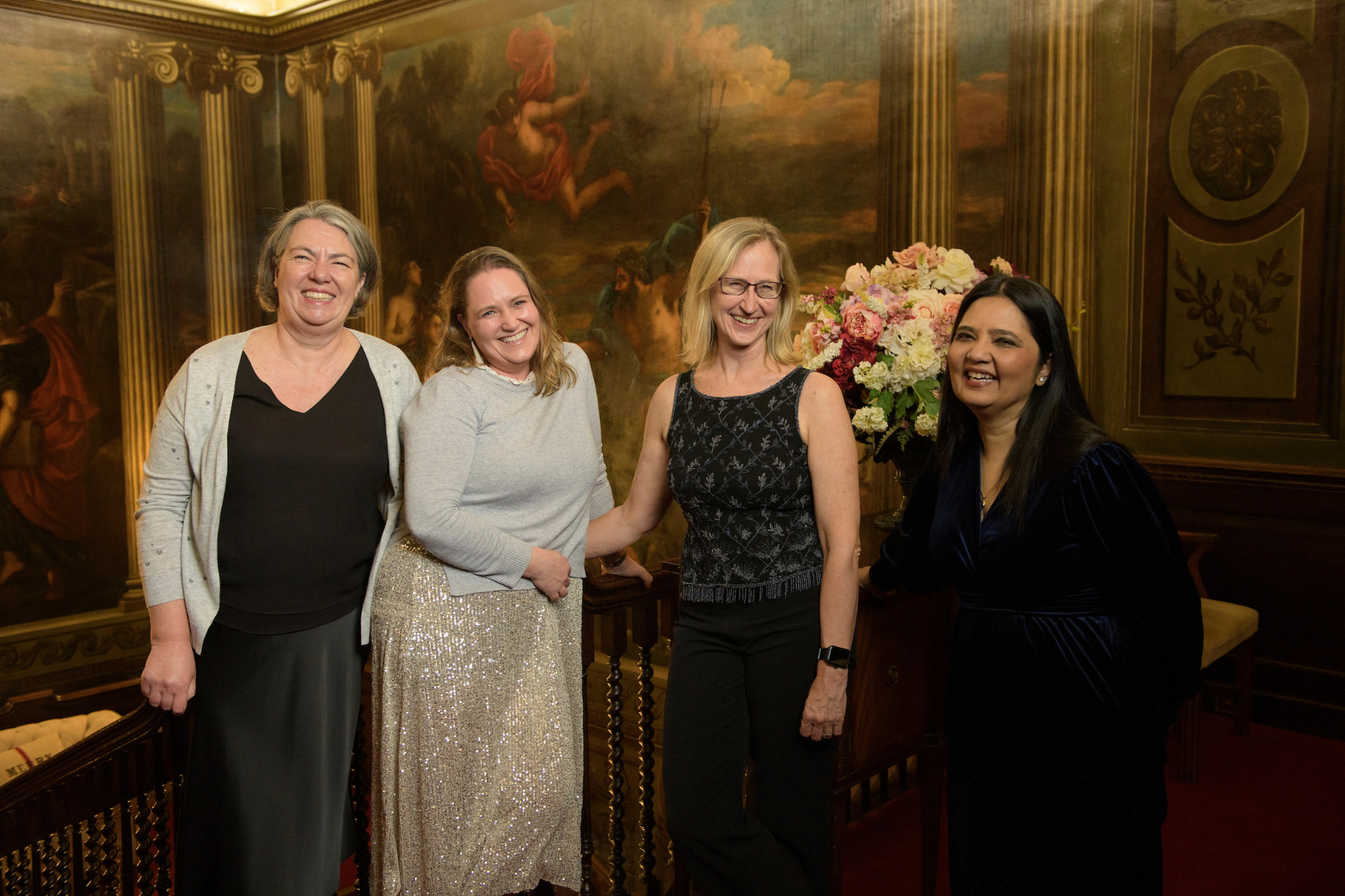 Four members smiling together on the staircase at the Surrey Hills Enterprises Christmas party
